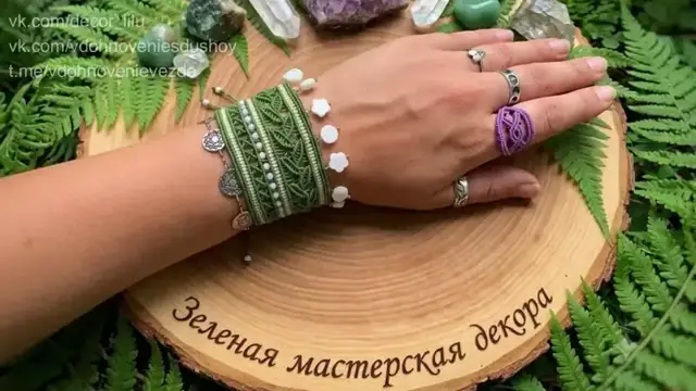 Широкий зелёный браслет с ажурными листьями, светлыми бусинами и перламутровыми подвесками.